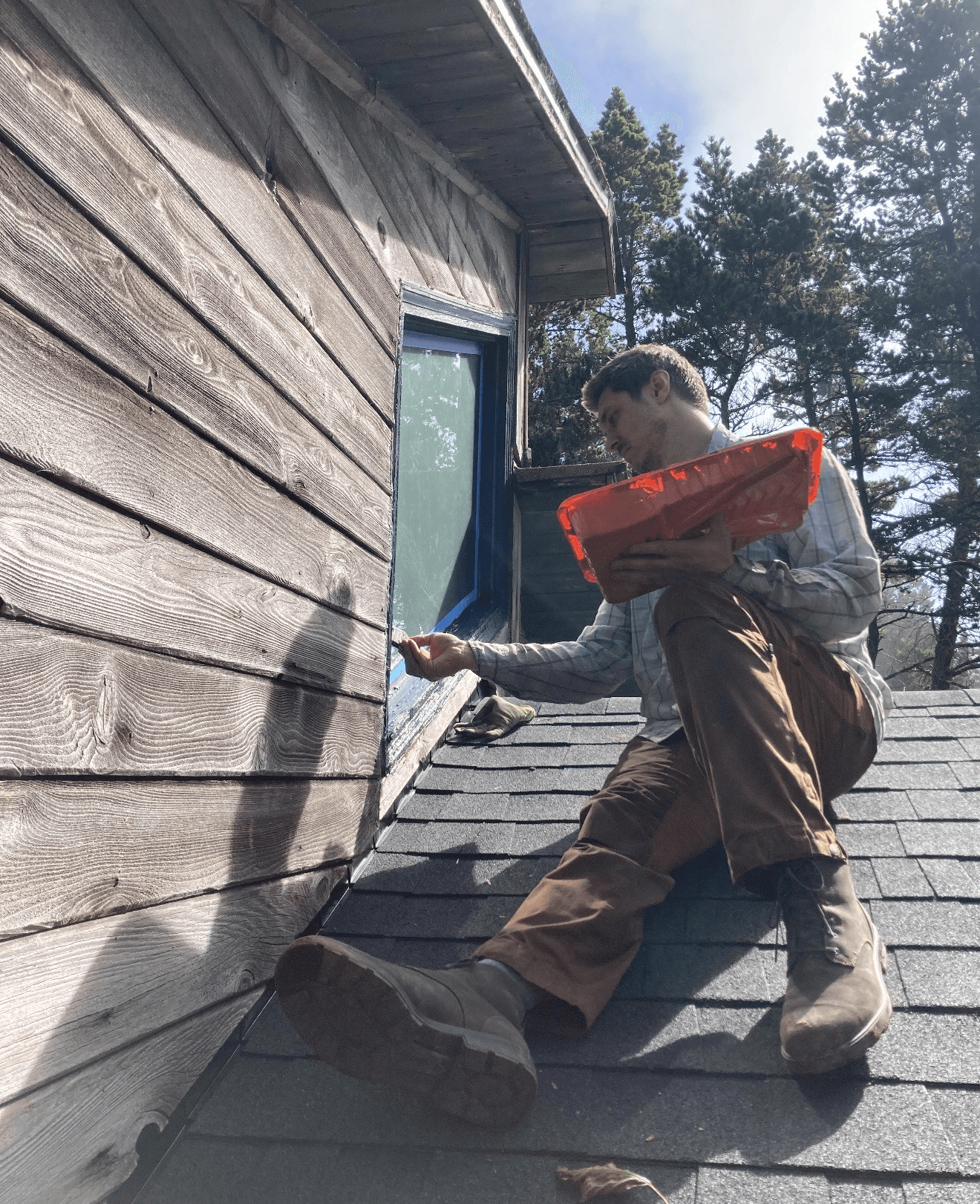Kane inspecting exterior window flashing on a roof